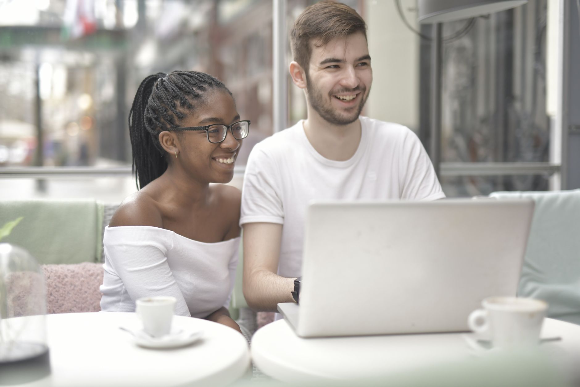 man and woman sitting on chair in front of table with laptop